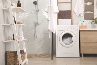 Photo of Stylish bathroom interior with modern washing machine