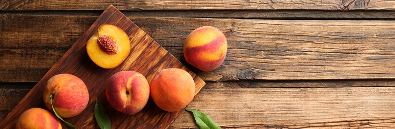 Fresh ripe peaches on wooden table, top view. Banner design with space for text