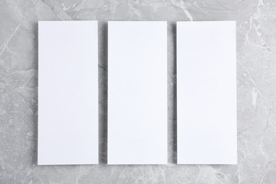 Photo of Blank palm cards on light grey marble background, flat lay. Mock up for design