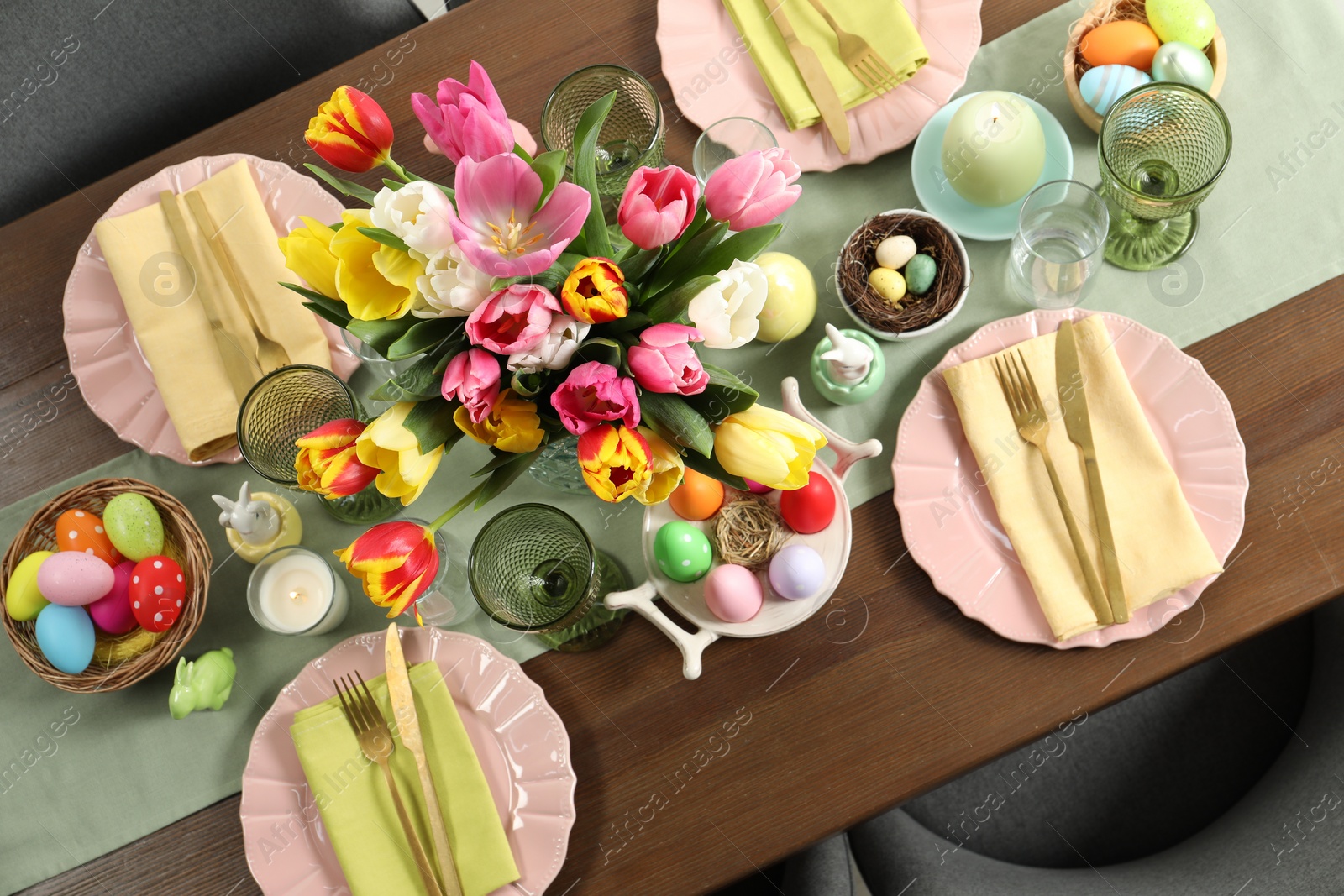 Photo of Festive Easter table setting with beautiful flowers and painted eggs, top view