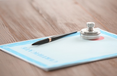 Certificate form, notary stamp and pen on wooden table