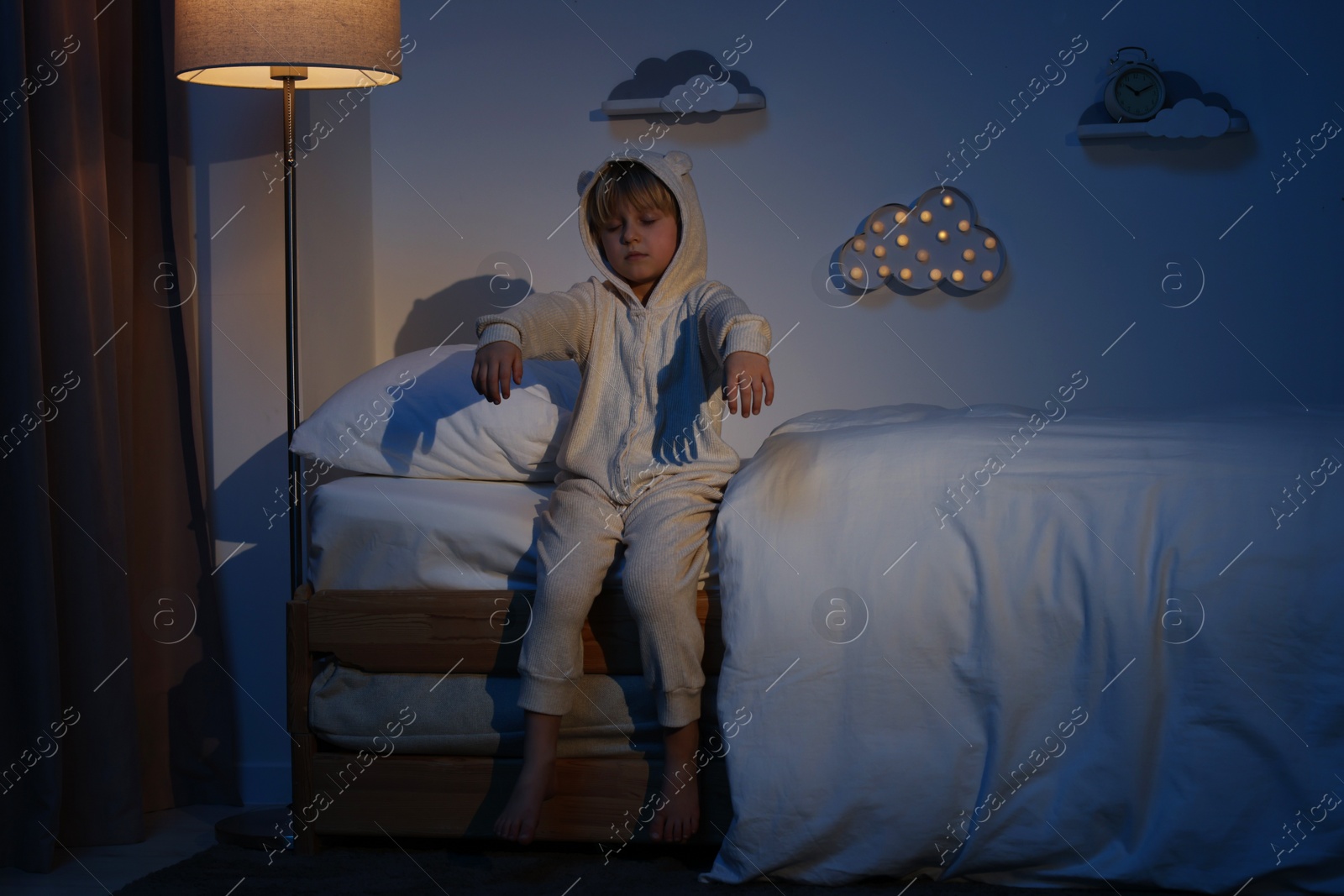 Photo of Boy in pajamas sleepwalking indoors at night