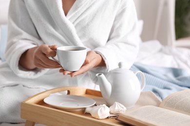 Woman with cup of hot tea at home, closeup