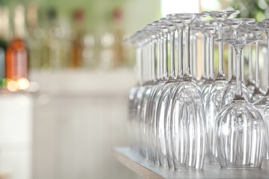 Photo of Empty glasses on wooden table against blurred background. Space for text
