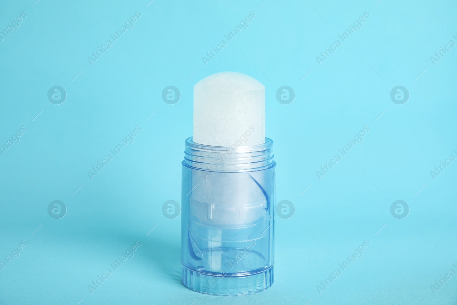 Photo of Natural crystal alum stick deodorant on light blue background