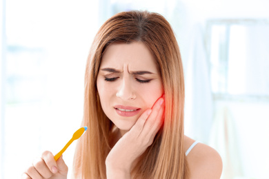 Woman suffering from strong toothache at home