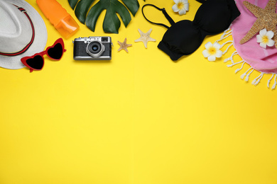 Photo of Flat lay composition with beach objects on yellow background. Space for text