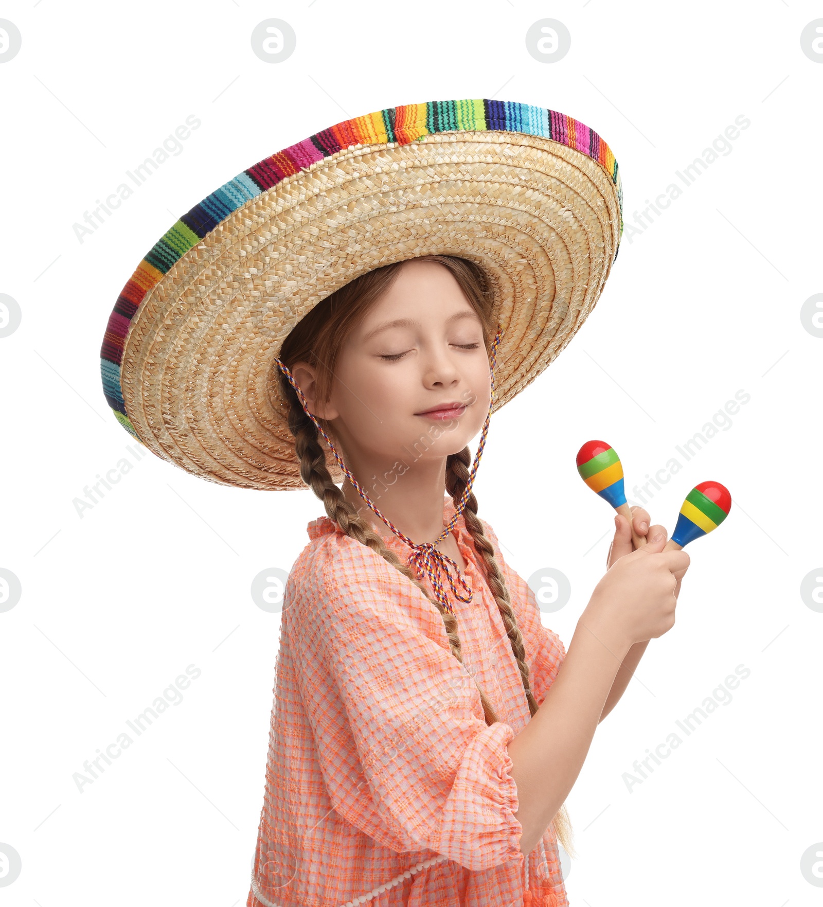 Photo of Cute girl in Mexican sombrero hat dancing with maracas on white background