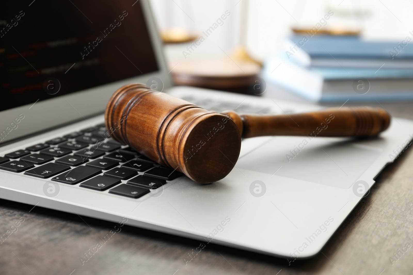 Photo of Laptop and gavel on table indoors, closeup. Cyber crime