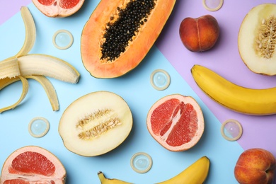 Photo of Flat lay composition with condoms and exotic fruits on color background. Erotic concept