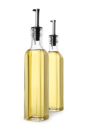 Glass bottles of cooking oil on white background