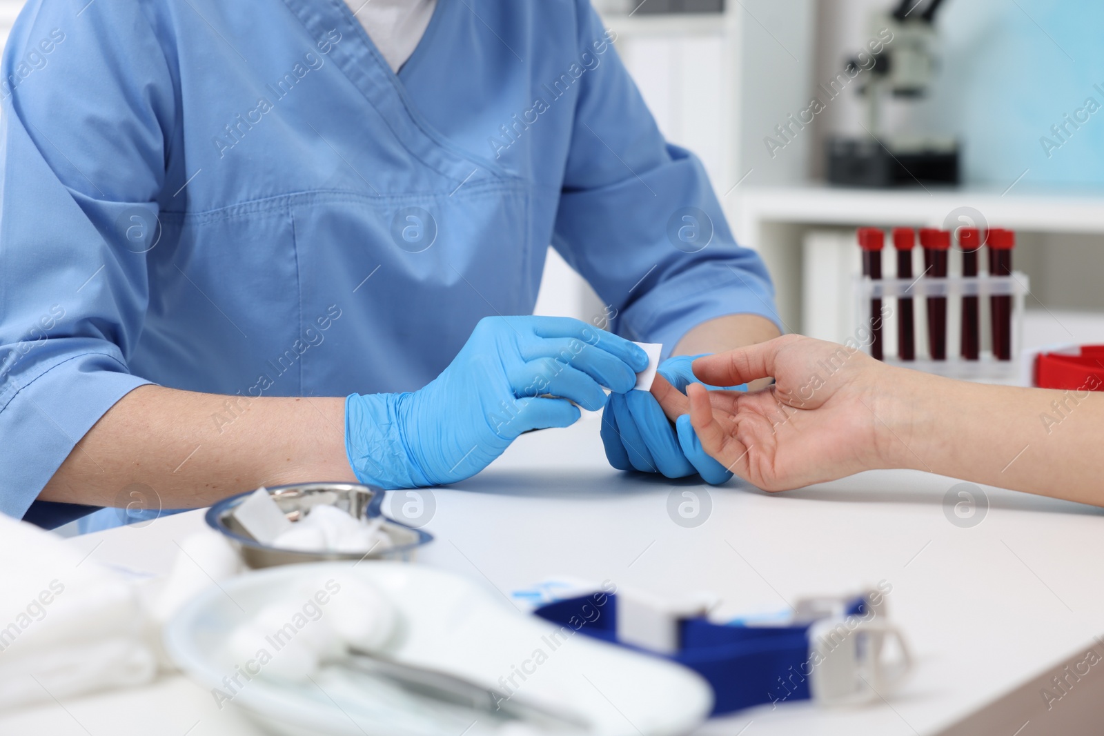 Photo of Laboratory testing. Doctor taking blood sample from patient at white table in hospital, closeup