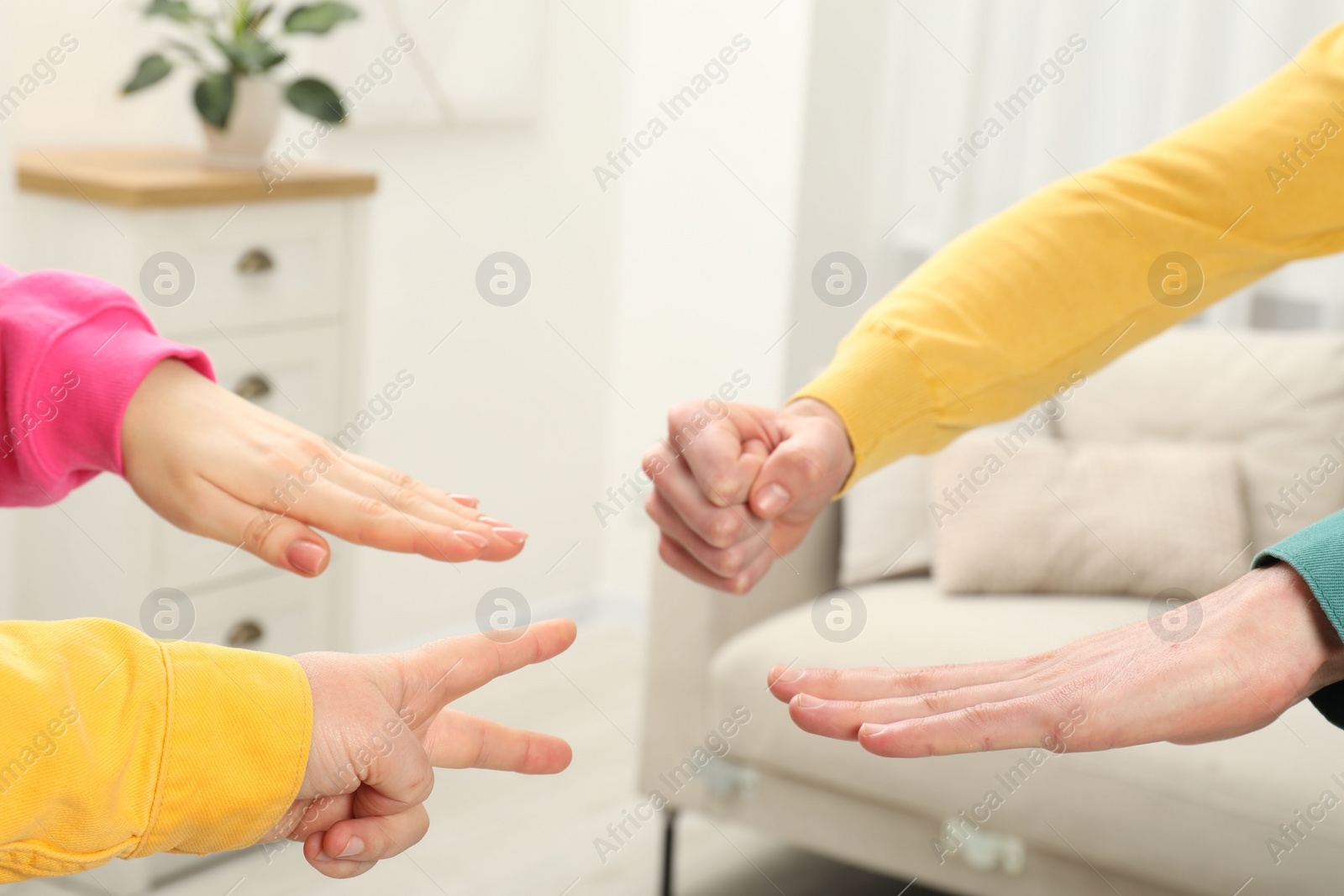 Photo of People playing rock, paper and scissors indoors, closeup