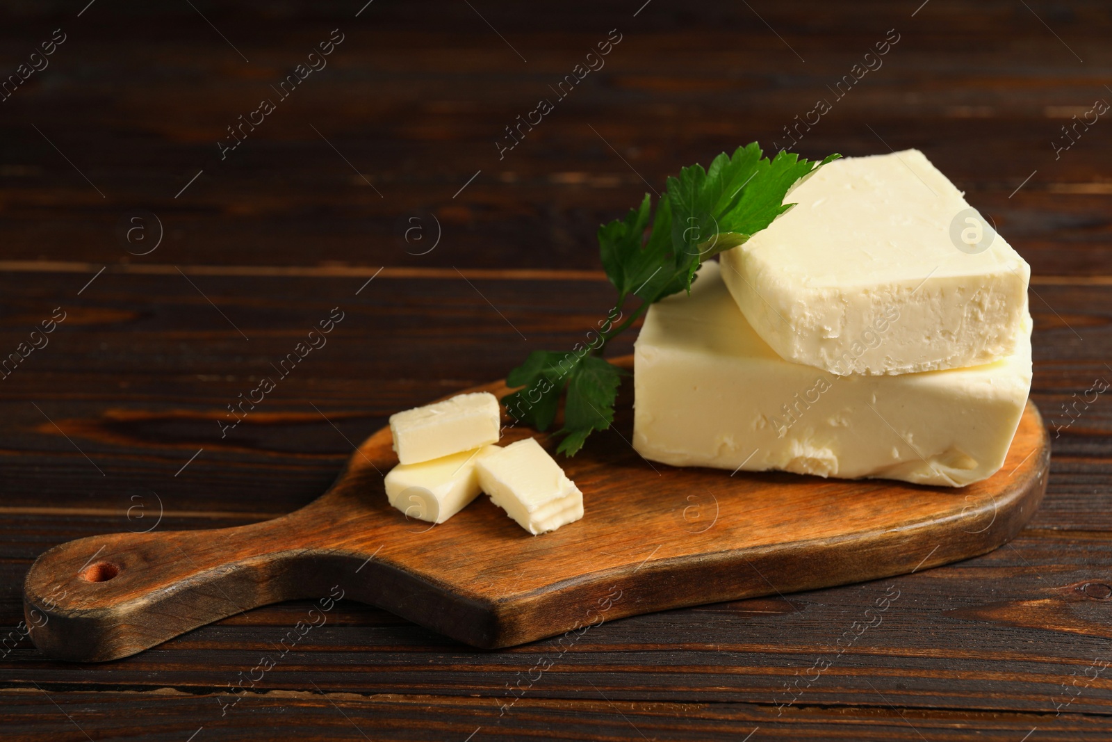 Photo of Tasty butter and parsley on wooden table