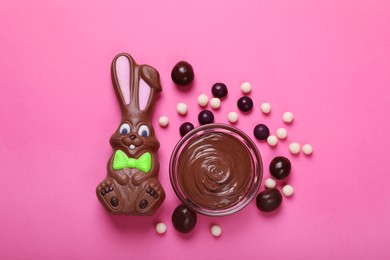Photo of Flat lay composition with chocolate Easter bunny and candies on pink background
