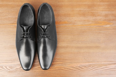 Photo of Elegant male shoes on wooden background