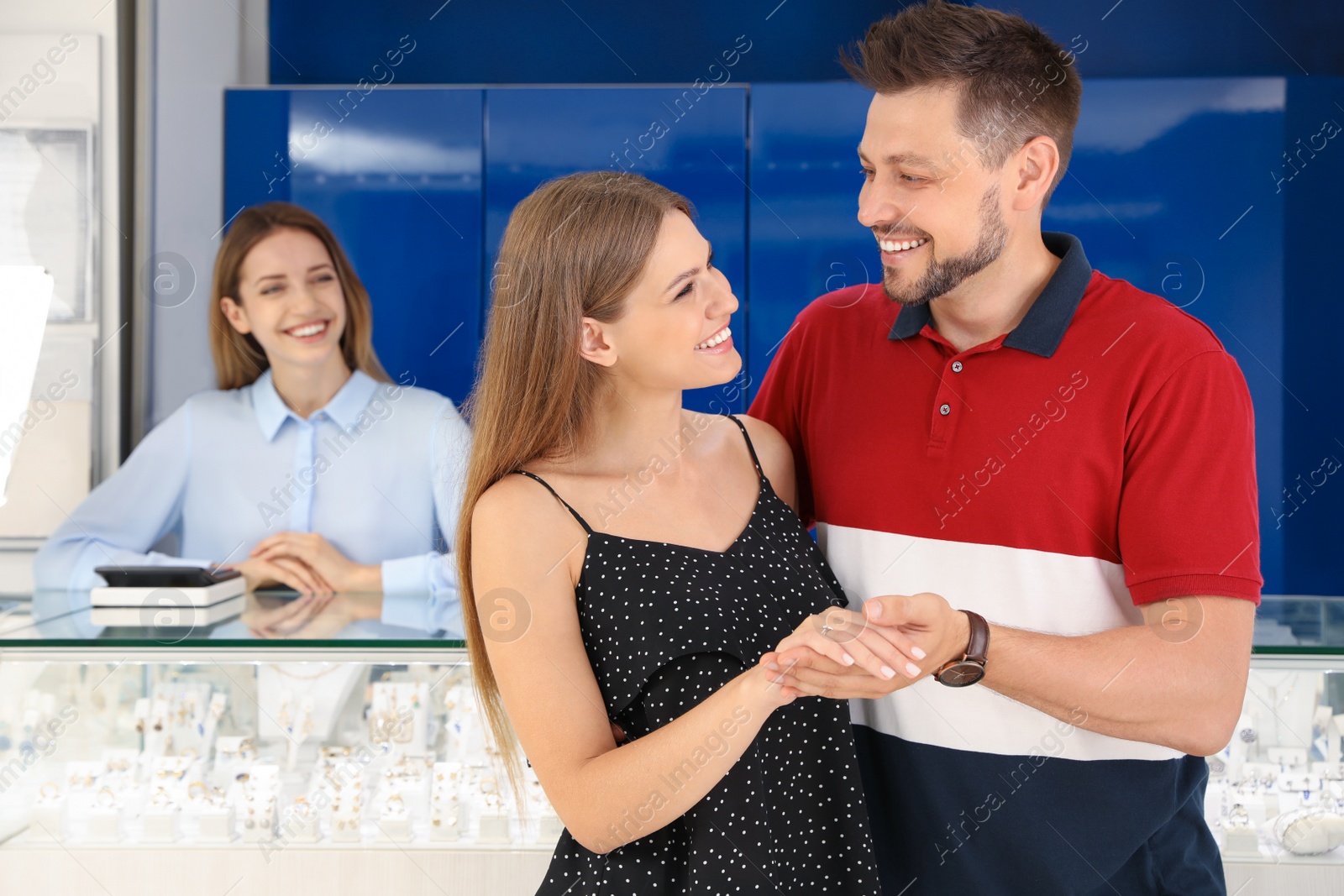Photo of Couple choosing engagement ring in jewelry store