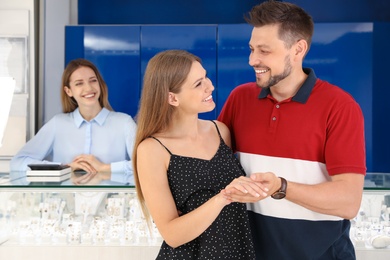 Couple choosing engagement ring in jewelry store