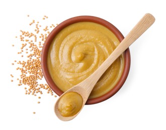 Fresh tasty mustard sauce in bowl, spoon and dry seeds isolated on white, top view