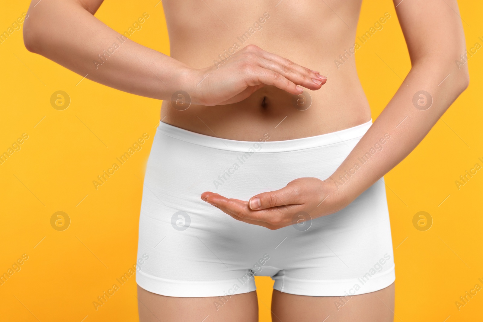 Photo of Woman holding something on orange background, closeup. Women's health