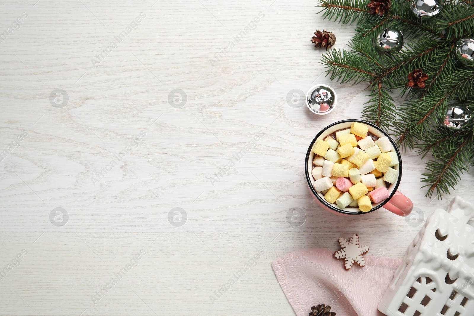 Photo of Delicious hot chocolate with marshmallows and Christmas decor on white wooden table, flat lay. Space for text