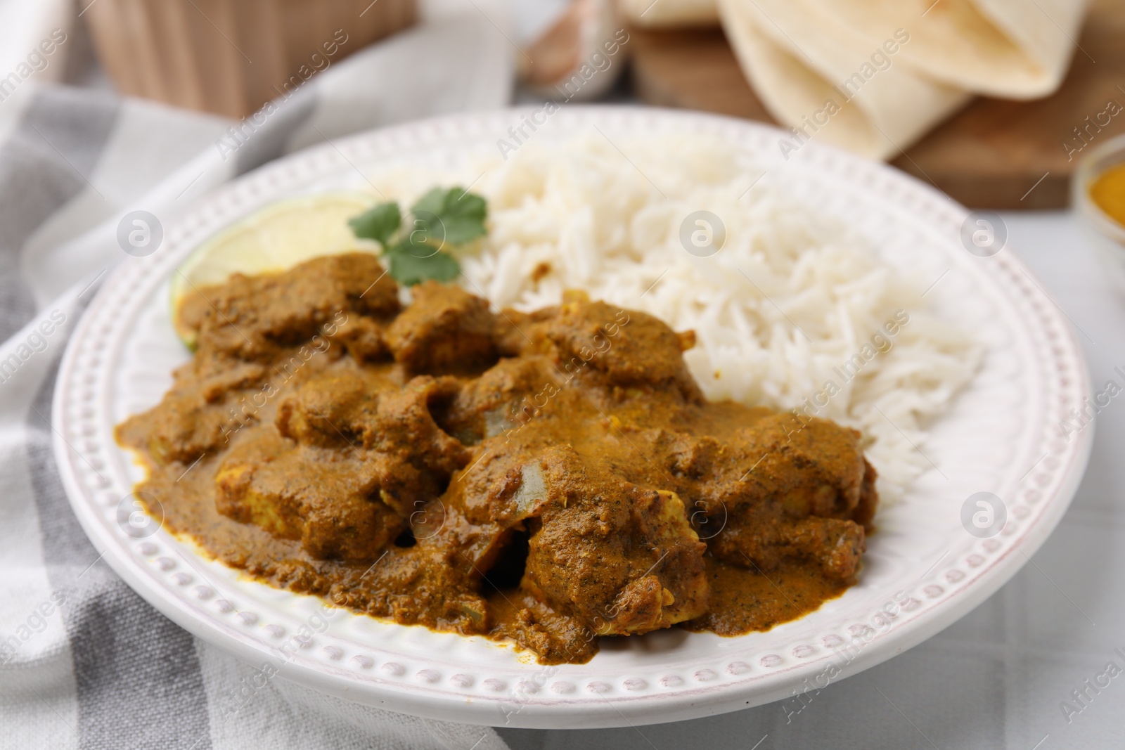 Photo of Delicious chicken curry with rice on table, closeup