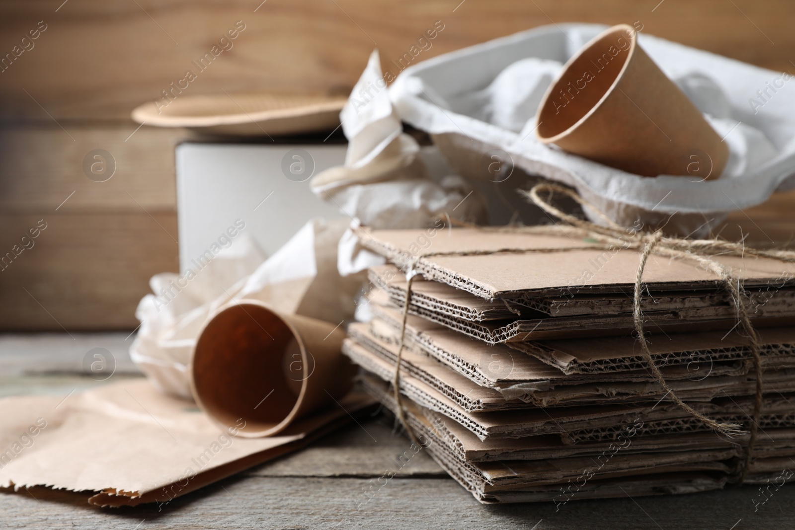 Photo of Different waste paper on wooden table, closeup. Space for text