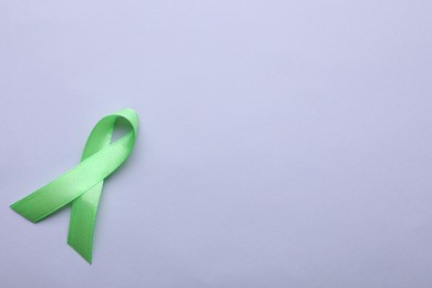 World Mental Health Day. Green ribbon on color background, top view with space for text