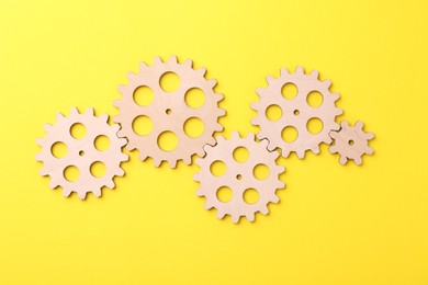 Business process organization and optimization. Scheme with wooden figures on yellow background, top view