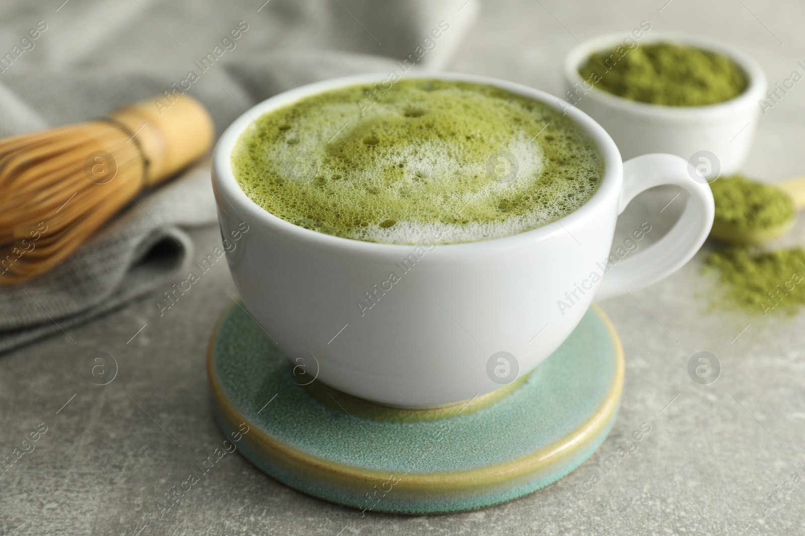 Photo of Cup of fresh matcha latte on light grey table, closeup
