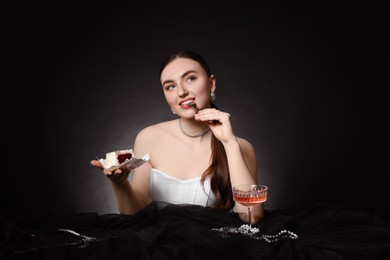 Photo of Fashionable photo of attractive woman with her Birthday cake and glass of wine on black background