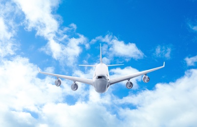 Airplane flying in blue sky with clouds. Air transportation