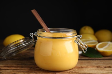 Delicious lemon curd in glass jar on wooden table