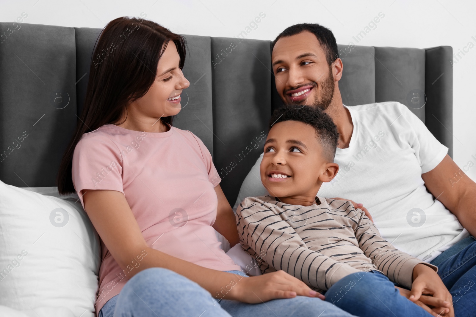 Photo of Happy international family spending time together on bed