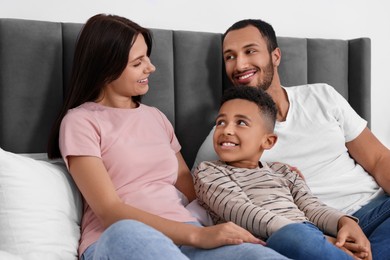 Happy international family spending time together on bed