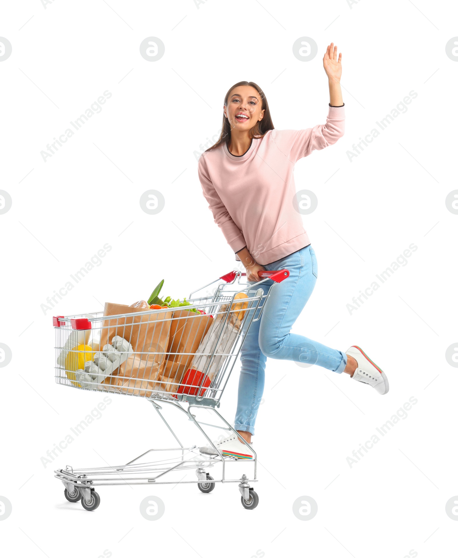 Photo of Young woman with full shopping cart on white background