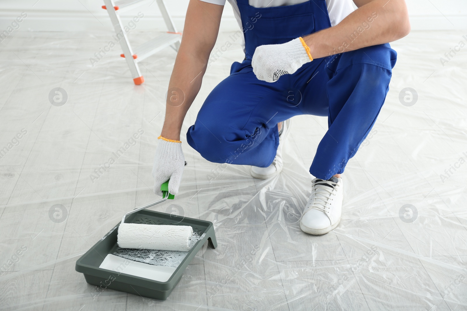 Photo of Man with roller and tray in room, closeup