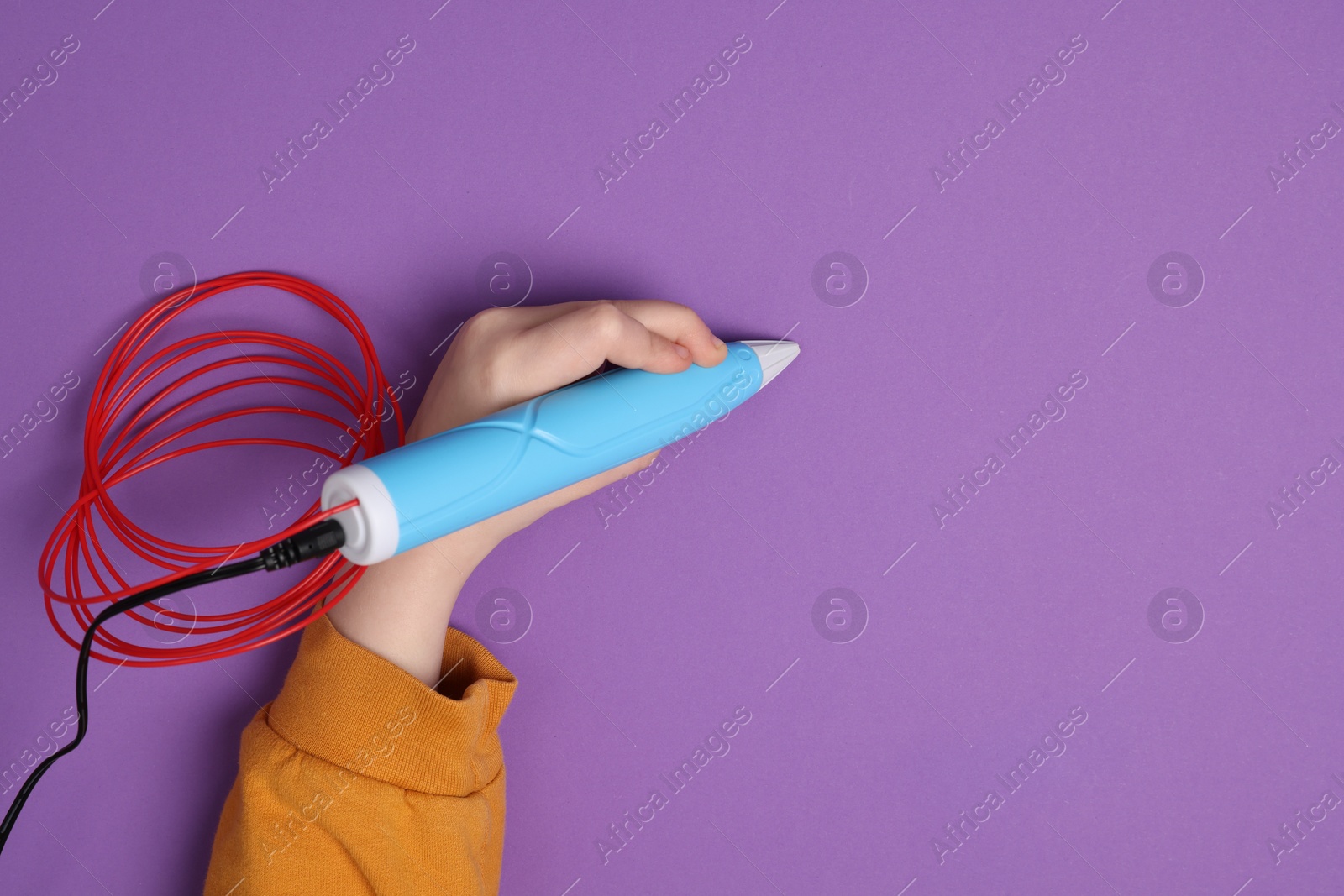 Photo of Boy drawing with stylish 3D pen on purple background, top view. Space for text
