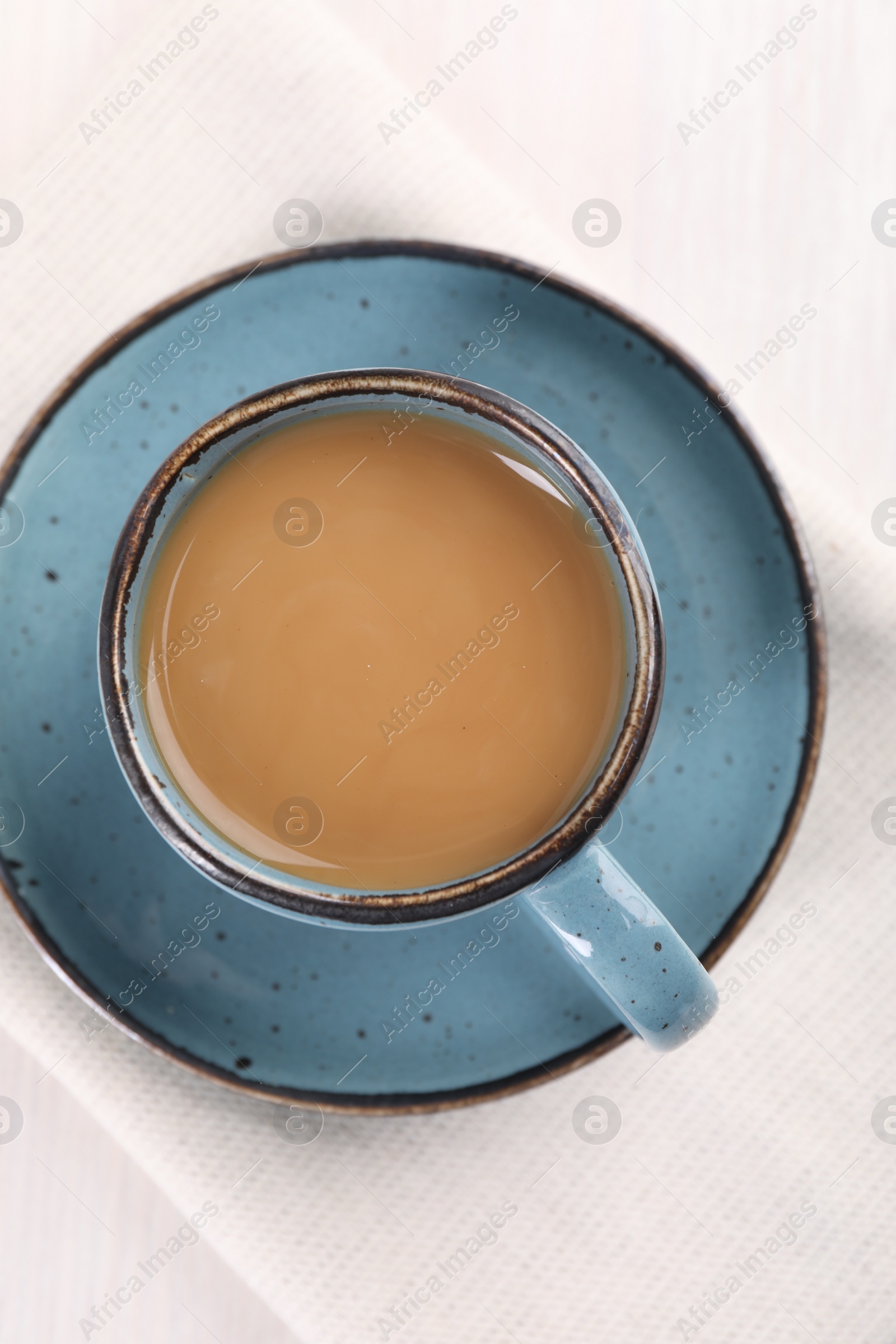 Photo of Delicious coffee in cup on white table, top view