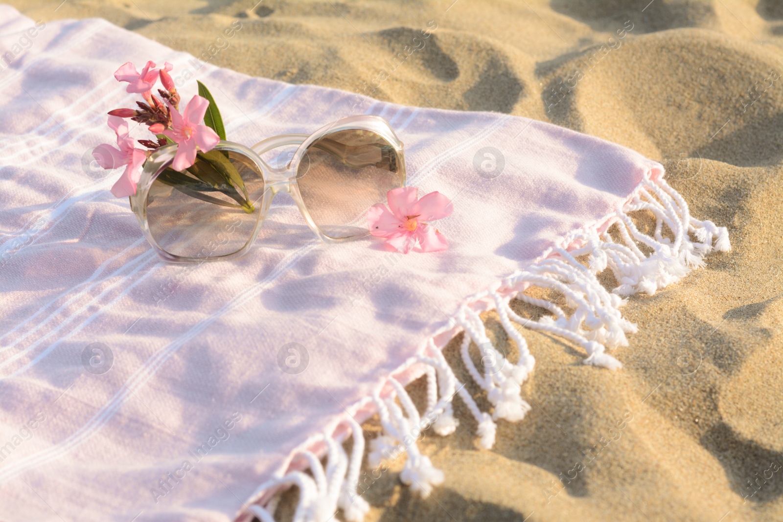 Photo of Beautiful sunglasses with tropical flower on blanket. Space for text