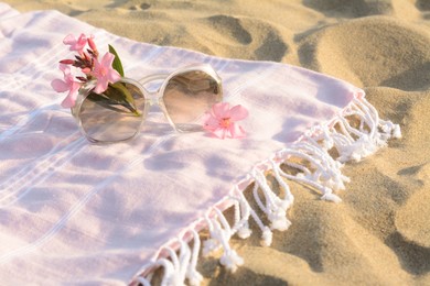Photo of Beautiful sunglasses with tropical flower on blanket. Space for text