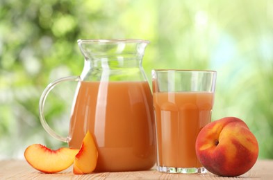 Tasty peach juice and fresh fruits on wooden table outdoors, closeup