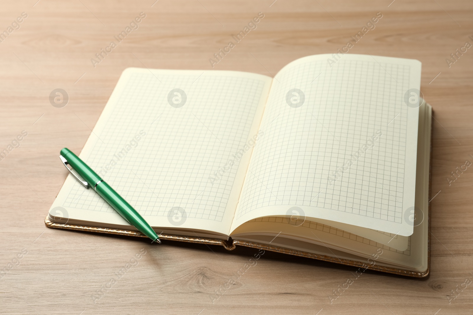 Photo of Open notebook and pen on wooden table. Personal planning