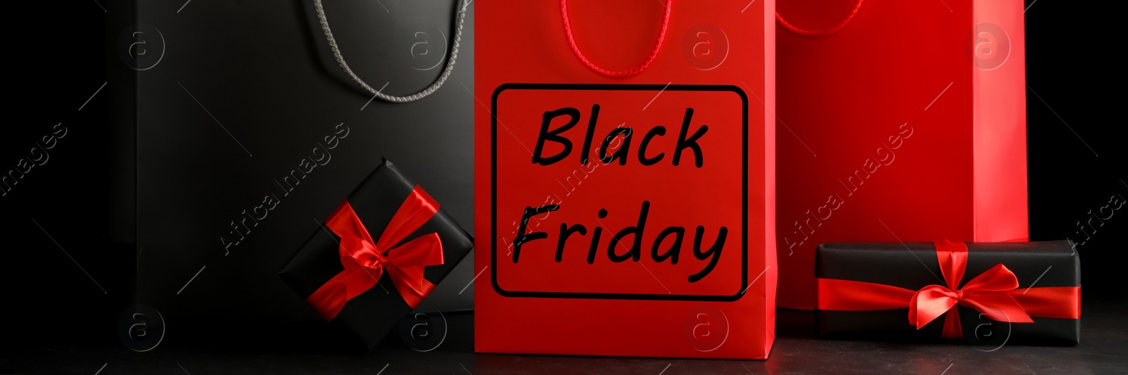 Image of Paper shopping bags and gift boxes on dark background, banner design. Black Friday sale