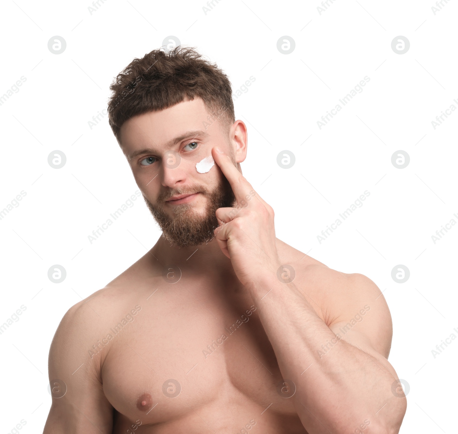 Photo of Handsome man applying moisturizing cream onto his face on white background