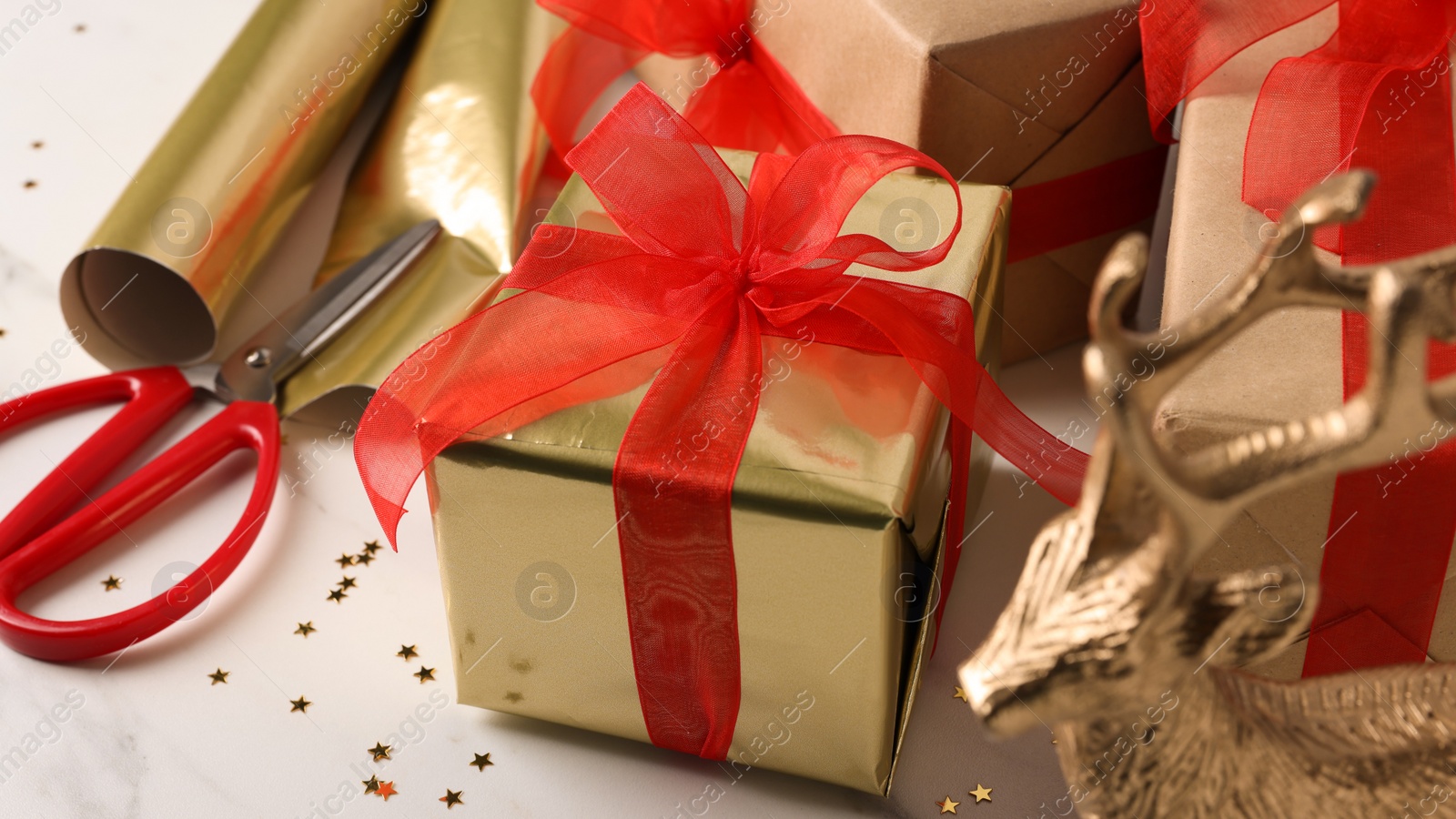 Photo of Beautifully wrapped gift boxes on white table, closeup