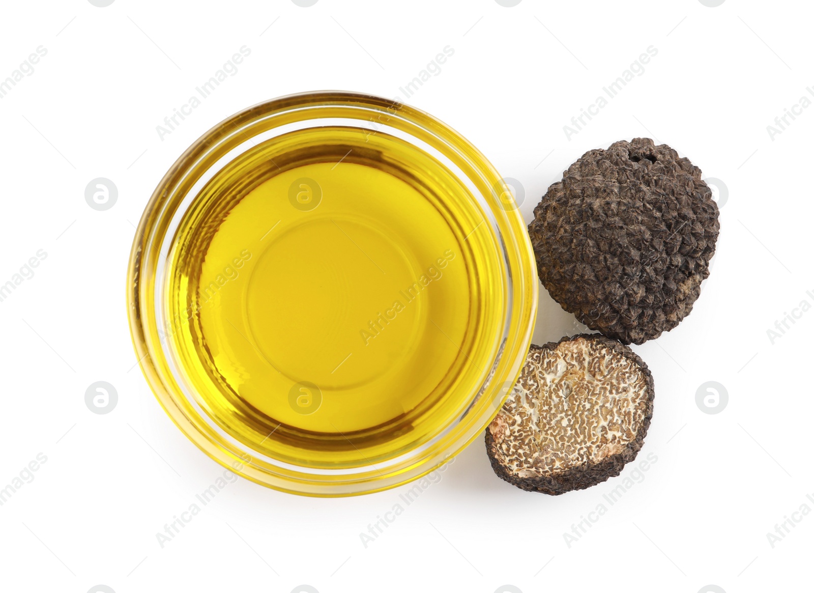 Photo of Glass bowl of oil and fresh truffles on white background, top view