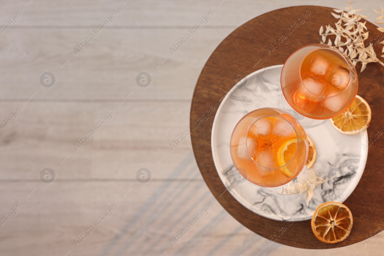 Photo of Tasty cocktail in glasses on wooden table in room, top view and space for text. Relax at home