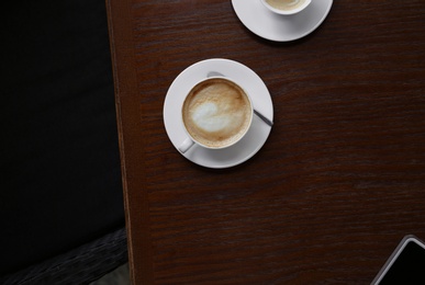 Photo of Cup of delicious aromatic coffee on table, top view