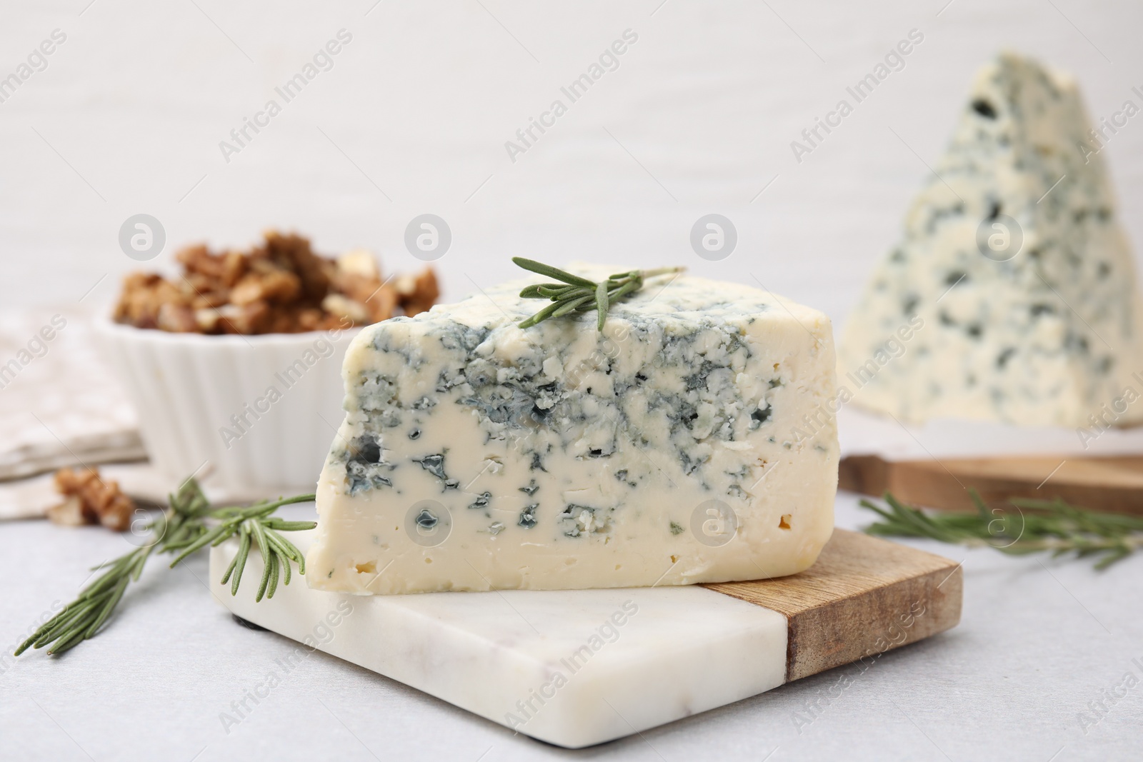 Photo of Tasty blue cheese with rosemary on light table